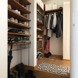 Imagen de armario y vestidor ecléctico con suelo de madera clara y suelo beige